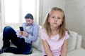 Internet addict father using mobile phone ignoring little sad daughter bored lonely and depressed Royalty Free Stock Photo