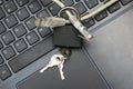 Internet cable passing through a closed iron lock with keys on a laptop keyboard data protection concept cybercrime Royalty Free Stock Photo