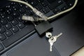 Internet cable passing through an open iron lock with keys on a laptop keyboard data protection concept cybercrime