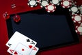 Internet casino and online gambling concept with two cards aces on a digital tablet, dice used to play the game of craps, black