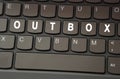 On the black keyboard, the inscription is highlighted in white - OUTBOX