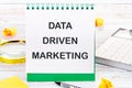 Internet concept. Business concept. Business idea. DATA DRIVEN MARKETING text on a blank sheet in a notebook