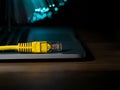 internet connection cable on laptop on table, unfocused fiber optic background Royalty Free Stock Photo