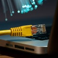 internet connection cable on laptop on table, unfocused fiber optic background Royalty Free Stock Photo