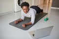 The internet gives you 247 access to online workouts. a young woman using a laptop while exercising at home.