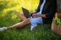 Hands of man sitting on grass typing on laptop Royalty Free Stock Photo