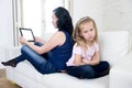 Internet network addict mother using digital tablet pad ignoring little sad daughter left alone bored