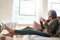 Internet, phone and woman relax on a sofa with social media, texting and browsing in her home. Girl, smartphone and