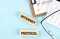INTERNET PROTOCOL text written on wooden block with clipboard,eye glasses and calculator Business concept