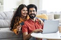 Internet Purchases. Portrait Of Smiling Indian Couple With Laptop And Credit Card Royalty Free Stock Photo