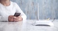 Internet router in the desk. Girl using smartphone Royalty Free Stock Photo
