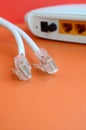 Internet router and Internet cable plugs lie on a bright orange