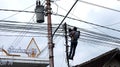 Internet service provider technician repairing a network of fiber optic cables climbing on a pole