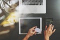 Internet shopping concept.Top view of hands working with calculator and laptop and credit card and tablet computer on dark wooden Royalty Free Stock Photo