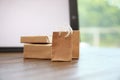 Internet shopping. Small bags and boxes near modern tablet on table indoors, closeup Royalty Free Stock Photo