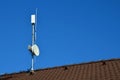 An internet signal amplifier is located on roof of the family house. parabolic antennas and heatsink at the amplifier. dangers of Royalty Free Stock Photo