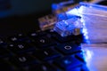 Internet switches on laptop computer keyboard, glowing optical fibres close up