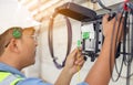 An internet technician is repairing or maintaining a fiber optic connection by opening a fiber optic connector