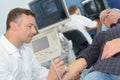 Internist examinating elderly patient with ultrasound