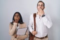 Interracial business couple wearing glasses bored yawning tired covering mouth with hand Royalty Free Stock Photo