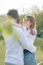 Interracial couple embraces in garden dressed in Ukrainian embroidered shirts