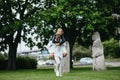 Interracial couple has fun and laughs in park on background of statues Polovtsian women Royalty Free Stock Photo