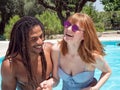 Interracial couple in love, play in the pool. The girl very white and red hair and the boy black Royalty Free Stock Photo
