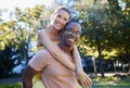 Interracial couple, love and portrait of people with support, care and smile on a summer park adventure. Piggyback, hug Royalty Free Stock Photo