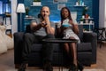 Interracial couple sitting together on couch watching television Royalty Free Stock Photo