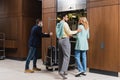 Interracial couple standing near hotel porter