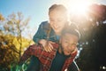 Interracial couple, sunshine and piggyback in park, summer and outdoor date together for happiness, smile and nature