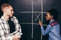 Interracial happy couple play tic tac toe game