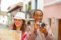 Interracial happy couple wearing casual clothes in urban envrionment, interacting and looking at map