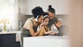 Interracial parents, kid and video call with laptop, headphones and wave hello with smile in kitchen. Mother, father and Royalty Free Stock Photo