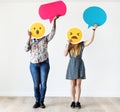 Interracial women holding an expressive emoticon face facial expression surprised and amazed social media and chat concept Royalty Free Stock Photo