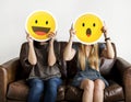 Interracial women holding an expressive emoticons