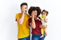 Interracial young family of black mother and hispanic father with daughter covering one eye with hand, confident smile on face and Royalty Free Stock Photo