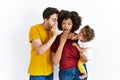 Interracial young family of black mother and hispanic father with daughter hand on mouth telling secret rumor, whispering Royalty Free Stock Photo