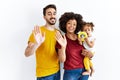 Interracial young family of black mother and hispanic father with daughter waiving saying hello happy and smiling, friendly Royalty Free Stock Photo