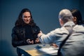 Interrogation of a homicidal maniac in the interrogation room. A police detective sits at a table with a suspect. Royalty Free Stock Photo