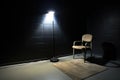an interrogation room spotlight shining on an empty chair