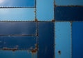 Intersecting blue metal panels with varying shades form a geometric pattern. Each panel is secured Royalty Free Stock Photo