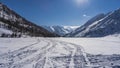 Intersecting snowmobile tracks are visible on the snow-covered surface of the frozen lake. Royalty Free Stock Photo