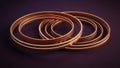 Intertwined copper rings with warm internal illumination and dark background Royalty Free Stock Photo