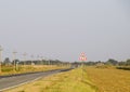 Interurban trail. Sign of narrowing the road. The asphalt road and the grassy side of the road. Royalty Free Stock Photo