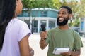 Interview of black male tv journalist with famous person outdoor in city