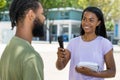 Interview of brazilian female tv journalist with famous person outdoor in city