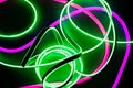 Interweaving of two neon ribbons on a textured background