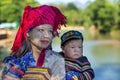 Intha tribal woman holding her child at back selling silk cloths in INle, Myanmar