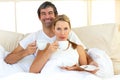 Intimate couple drinking coffee lying in the bed Royalty Free Stock Photo